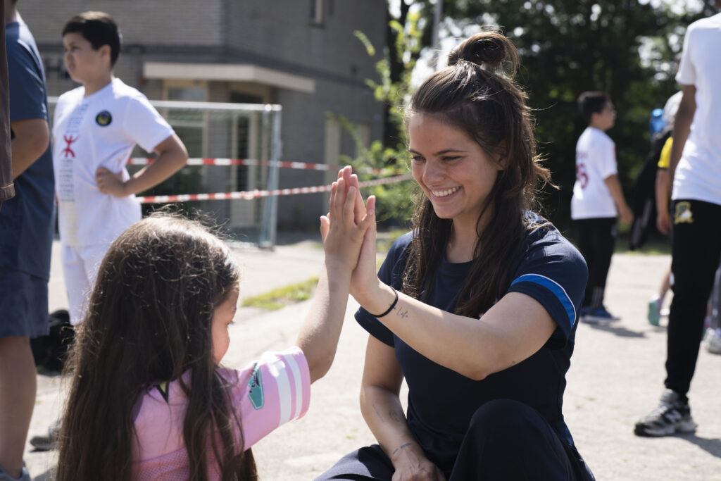 Buurtsportcoach geeft meisje een high five